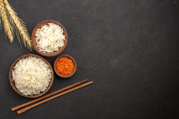 Bovenaanzicht heerlijke gekookte rijst vlakte smakelijke maaltijd binnen bord op de donkere ruimte