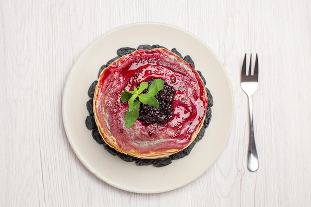 Bovenaanzicht heerlijke gelei pannenkoeken met rozijnen en fruit gelei op witte achtergrond gelei biscuit dessert jam sweet