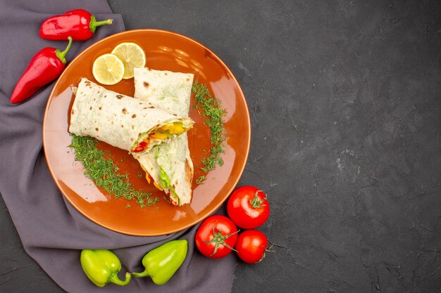 Bovenaanzicht heerlijke gesneden shaurma sandwich met verse groenten op de donkere achtergrond hamburger maaltijd sandwich snack brood