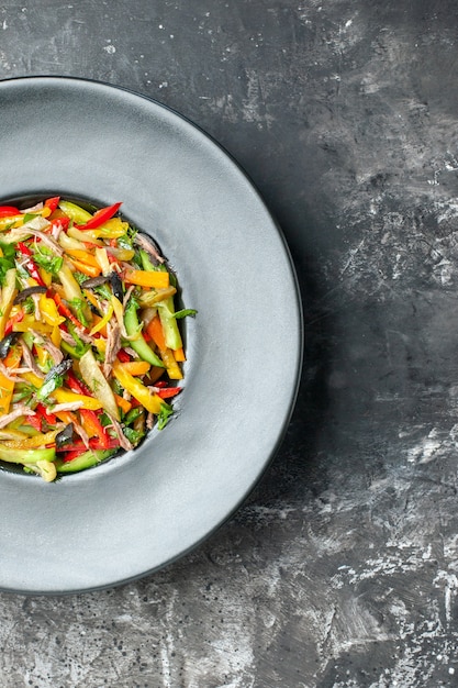 Bovenaanzicht heerlijke groentesalade binnen plaat op de grijze achtergrond