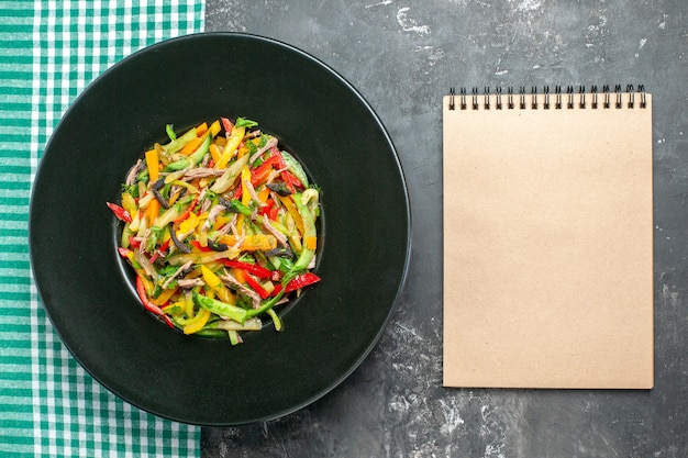 Bovenaanzicht heerlijke groentesalade binnen plaat op de grijze achtergrond