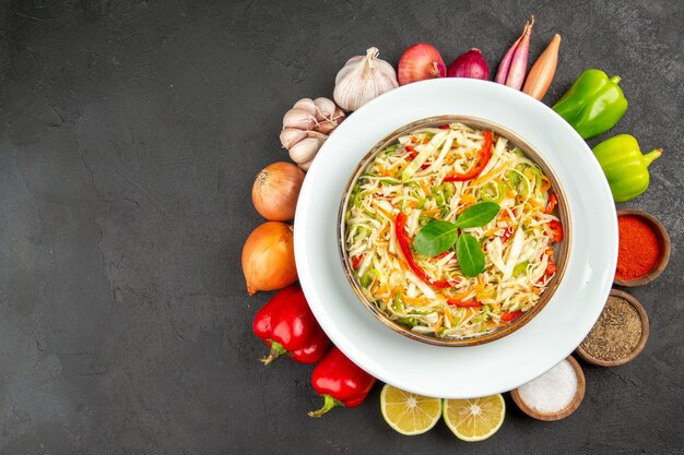 Bovenaanzicht heerlijke groentesalade met kruiden op grijze achtergrond