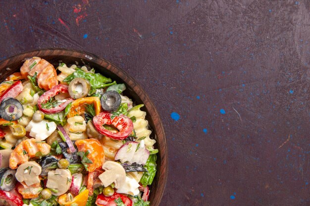 Bovenaanzicht heerlijke groentesalade met olijven, tomaten en champignons op donkere bureausalade gezondheidssnack lunch groente