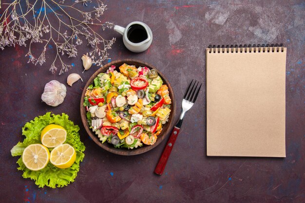 Bovenaanzicht heerlijke groentesalade met schijfjes citroen en groene salade op donkere achtergrond maaltijd gezondheidsdieet salade