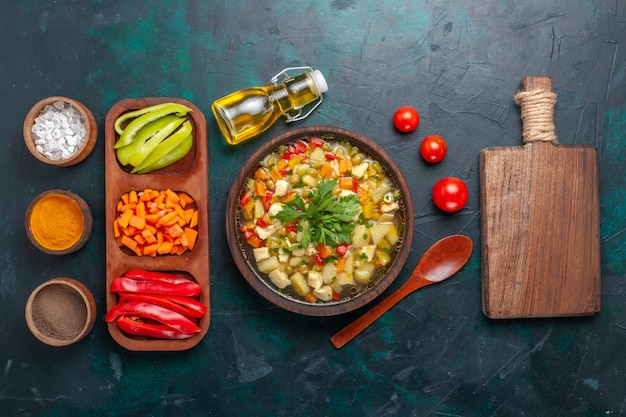 Bovenaanzicht heerlijke groentesoep met verschillende ingrediënten en kruiden op donkere bureau soep groentesaus eten warm eten maaltijd