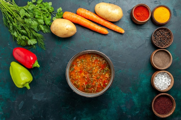 Gratis foto bovenaanzicht heerlijke groentesoep met verschillende kruiden op donkergroene ondergrond voedsel maaltijd groente ingrediënten soepproducten