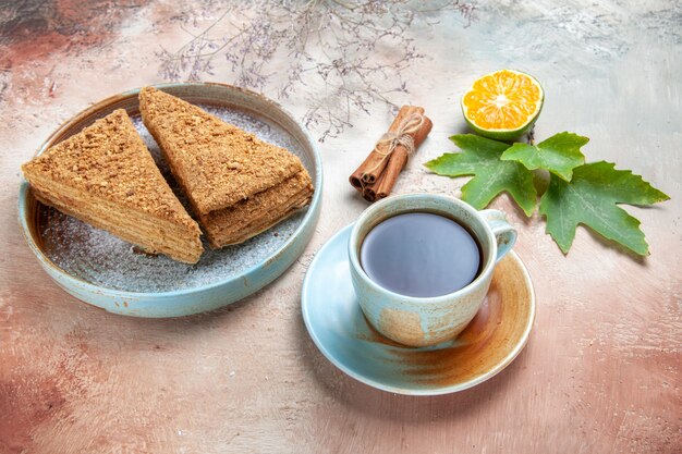 Bovenaanzicht heerlijke honingcake met kopje thee op licht