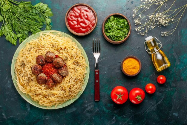 Bovenaanzicht heerlijke Italiaanse pasta met gehaktballen en tomatensaus op het blauwe bureau deeg pastaschotel vlees diner eten Italië