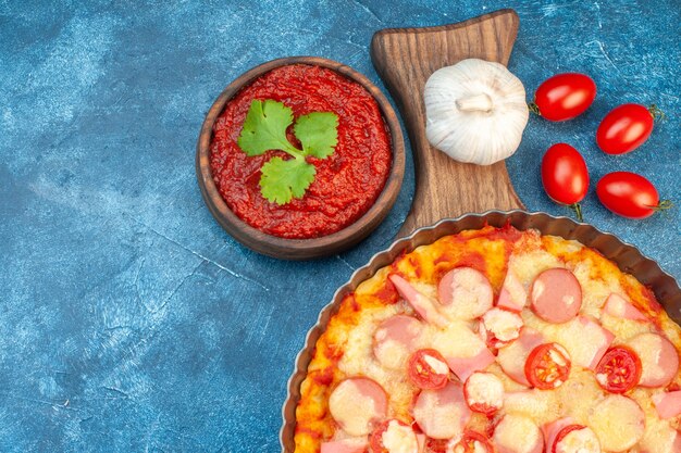 Bovenaanzicht heerlijke kaas pizza met worstjes en tomaten op blauwe achtergrond Italiaans eten deeg cake fastfood foto kleur