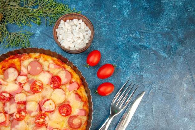 Bovenaanzicht heerlijke kaas pizza met worstjes en tomaten op de blauwe achtergrond voedsel deeg cake kleur foto fastfood italiaans