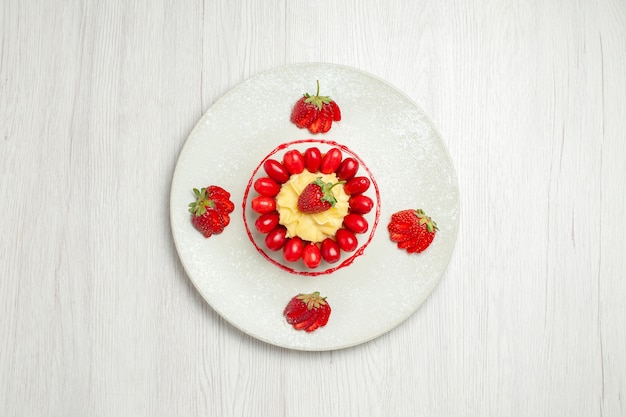 Gratis foto bovenaanzicht heerlijke kleine cakes met fruit op lichtwit bureau