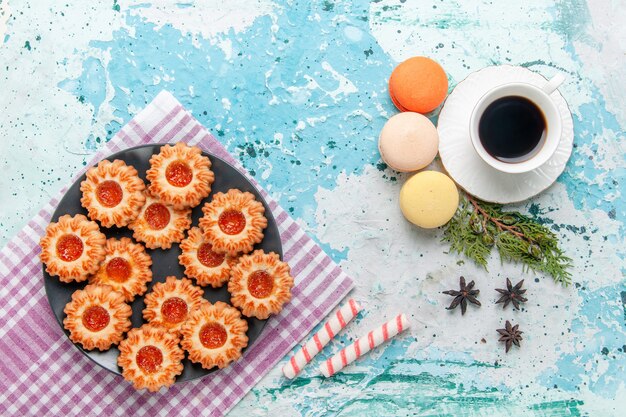 Bovenaanzicht heerlijke kleine koekjes met Franse macarons en koffie op blauwe bureau koekjes koekjes zoete kleur thee