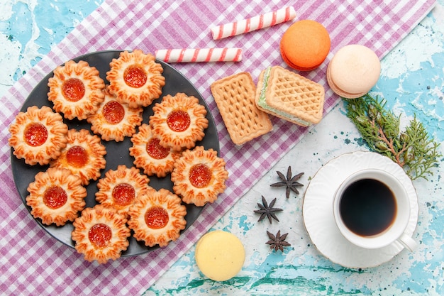 Gratis foto bovenaanzicht heerlijke kleine koekjes met sinaasappeljam, koffie en wafels op blauw oppervlak koekjeskoekje zoete suiker kleur thee