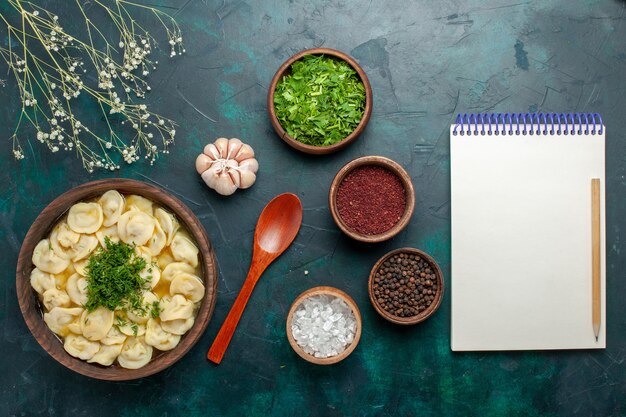 Bovenaanzicht heerlijke knoedelsoep met verschillende kruiden op donkergroen bureau soep eten vlees groente deeg