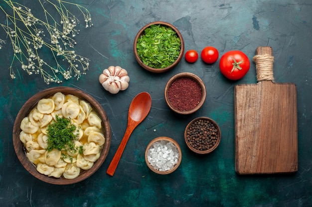 Bovenaanzicht heerlijke knoedelsoep met verschillende kruiden op donkergroen oppervlak soep eten vlees groentedeeg