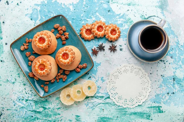 Gratis foto bovenaanzicht heerlijke koekjes met gedroogde ananasringen op de lichtblauwe oppervlakte koekjeskoekje zoete suikerkleur