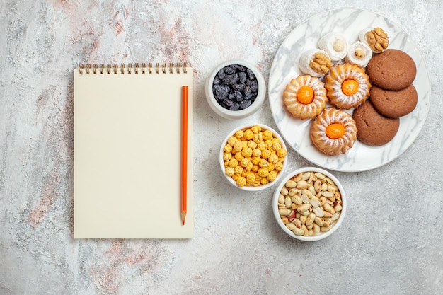 Bovenaanzicht heerlijke koekjes met snoep op witte achtergrond cookie biscuit zoete cake suiker thee