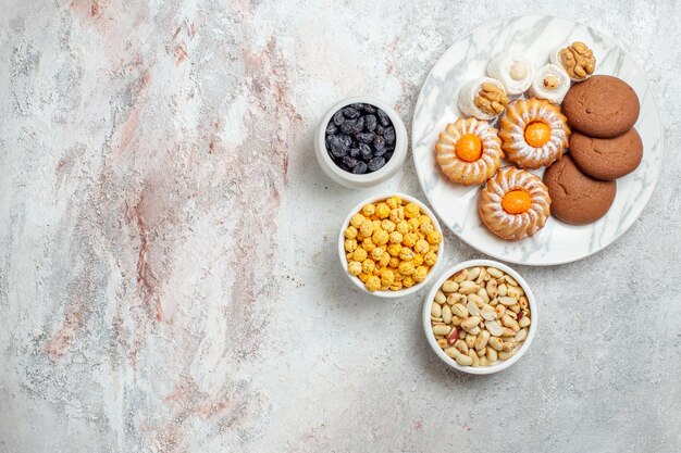 Bovenaanzicht heerlijke koekjes met snoep op witte achtergrond cookie biscuit zoete cake thee suiker