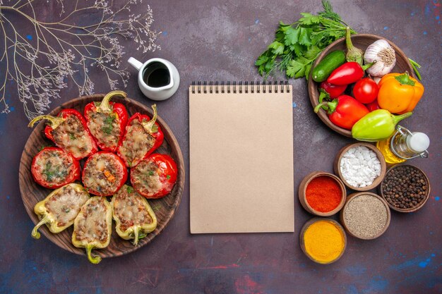 Bovenaanzicht heerlijke paprika gekookte schotel met gehakt en kruiden op donkere achtergrond diner eten bak zout gerecht vlees