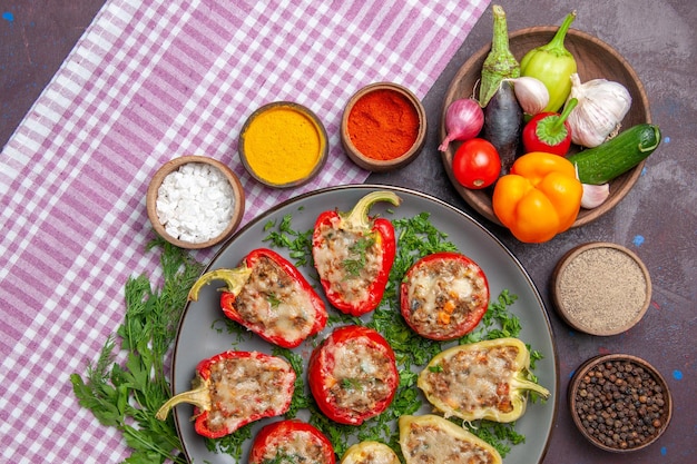 Bovenaanzicht heerlijke paprika smakelijke gekookte maaltijd met vlees en groenten op de donkere achtergrond pittige maaltijd diner schotel peper eten