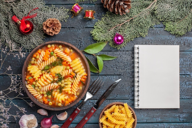 Bovenaanzicht heerlijke pastasoep van spiraal Italiaanse pasta op de donkerblauwe bureauschotel keuken kleur soep pasta