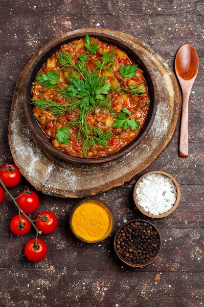 Bovenaanzicht heerlijke plantaardige maaltijd gesneden gekookt met verse groenten en kruiden op donkere ondergrond maaltijd eten diner saus soep