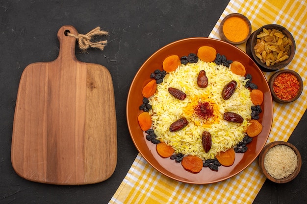 Gratis foto bovenaanzicht heerlijke plov met verschillende rozijnen op de donkere ruimte