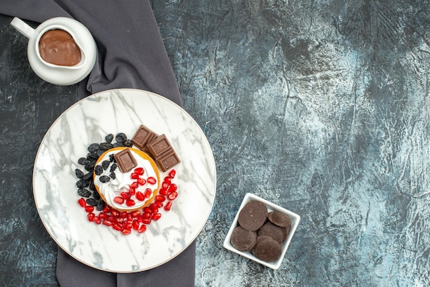 Bovenaanzicht heerlijke romige cake met chocolade en rozijnen op licht-donkere achtergrond