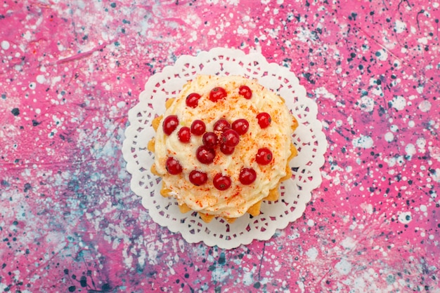 Bovenaanzicht heerlijke ronde cake met verse rode veenbessen op de paarse bureausuiker