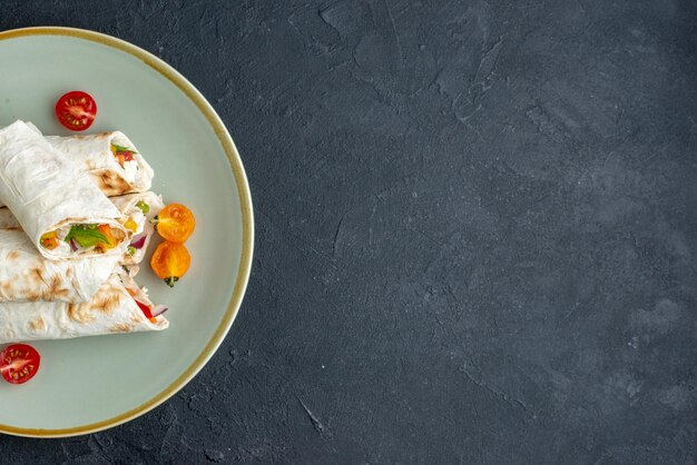 Bovenaanzicht heerlijke shaurma gesneden pitabroodje binnen plaat op donkere ondergrond hamburger eten maaltijd grill snack lunch brood toast vrije ruimte