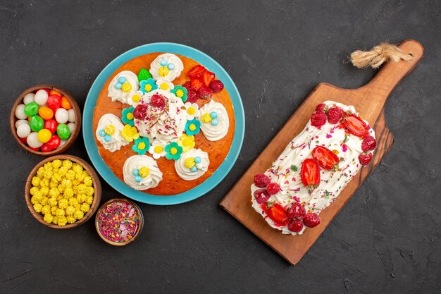 Bovenaanzicht heerlijke slagroomtaart met fruit en snoep op de donkere achtergrond taartkoekje, zoete theekoekjestaart