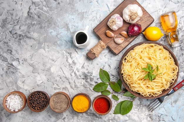 Bovenaanzicht heerlijke spaghetti met kruiden op witte tafel maaltijd pasta deeg kleur