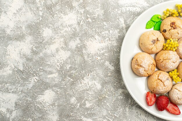 Bovenaanzicht heerlijke suikerkoekjes binnen plaat op witte bureausuiker koekjes zoete koektheecake