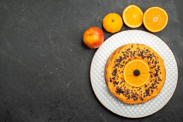 Gratis foto bovenaanzicht heerlijke taart met chocoladeschilfers en stukjes sinaasappel op donkere oppervlakte fruit dessert taart cake biscuit thee