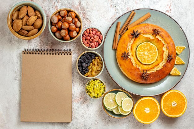 Bovenaanzicht heerlijke taart met noten en citrusvruchten op witte achtergrond fruit zoete noot cake taart biscuit