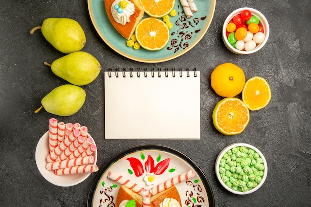 Gratis foto bovenaanzicht heerlijke taart plakjes met verse mandarijnen op grijze achtergrond taart fruit snoep deeg thee cake