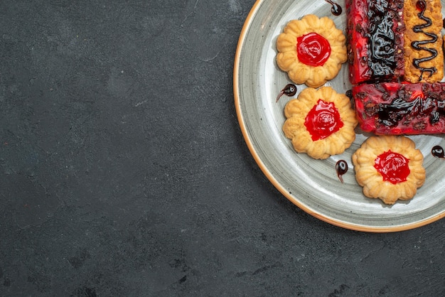 Bovenaanzicht heerlijke taarten fruitige snoepjes met koekjes op donkere achtergrond suiker thee koekje biscuit cake zoete taart