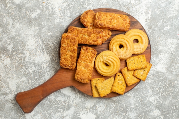 Gratis foto bovenaanzicht heerlijke taarten met crackers en koekjes op witte achtergrond