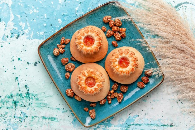 Bovenaanzicht heerlijke taarten met koekjes en zoete noten op lichtblauwe ondergrond bakken biscuit cake zoete suikernoot