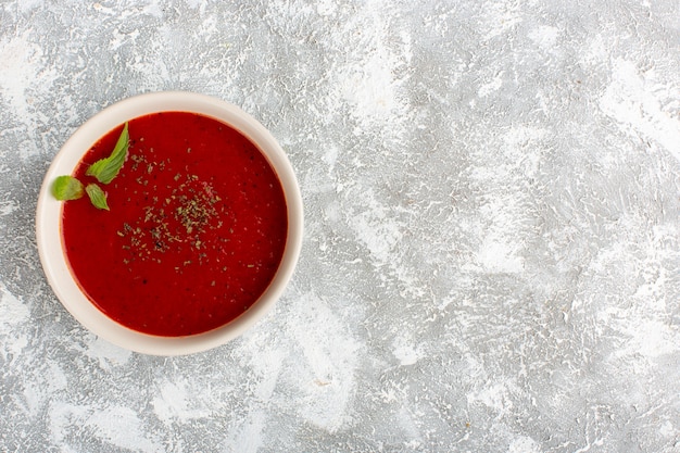 Bovenaanzicht heerlijke tomatensoep op grijze tafel, soep maaltijd diner groente