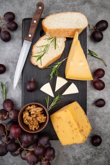 Bovenaanzicht heerlijke variëteit aan kaas met walnoten en druiven