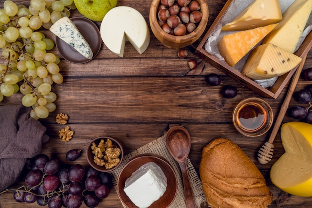 Bovenaanzicht heerlijke verscheidenheid aan kaas met brood en druiven