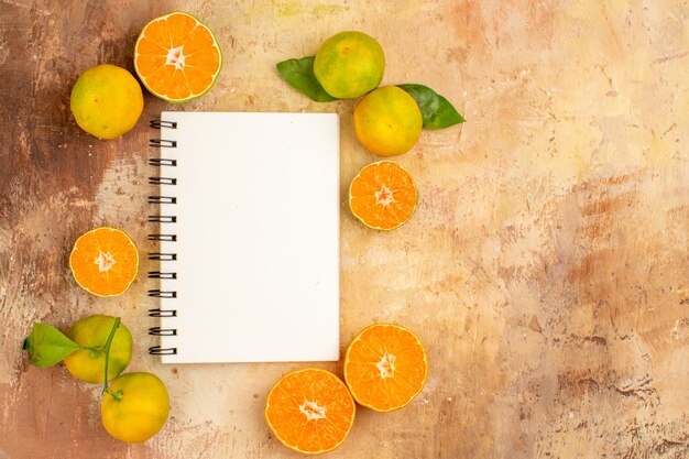 Bovenaanzicht heerlijke verse mandarijnen met notitieblok