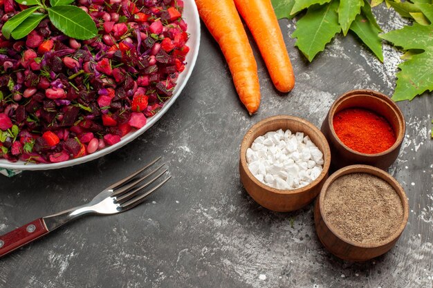 Bovenaanzicht heerlijke vinaigrette bietensalade binnen plaat op donkere ondergrond