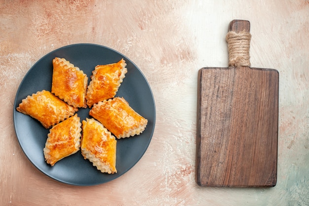 Bovenaanzicht heerlijke zoete gebakjes in plaat op witte tafelgebak zoete taarttaarten