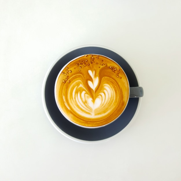 Bovenaanzicht heet latte koffie in witte kop. Geïsoleerd op een witte achtergrond.