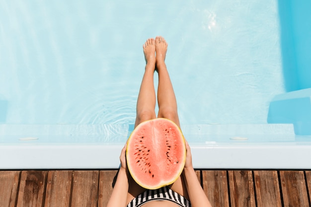 Bovenaanzicht helft van watermeloen boven zwembad
