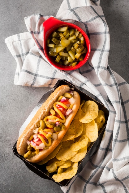 Bovenaanzicht hotdog en chips met Amerikaanse vlag en augurken