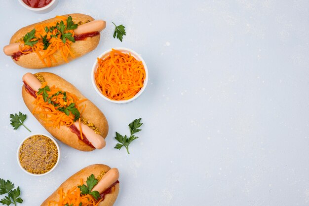 Bovenaanzicht hotdogs en wortelen met kopie-ruimte