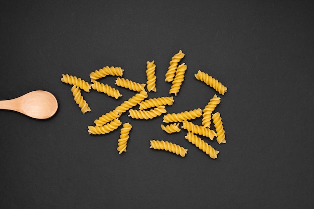 Bovenaanzicht houten lepel met ongekookte fusilli